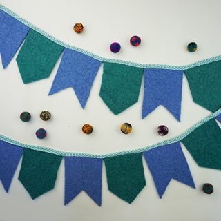 Make this wool felt banner DIY with craft felt or repurposed felted sweaters! A colorful and eco-friendly way to decorate your home or celebrate a party!